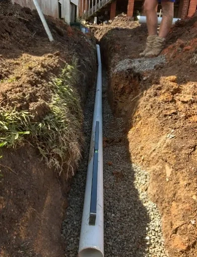 Drainage pipe bedded on gravel in a trench